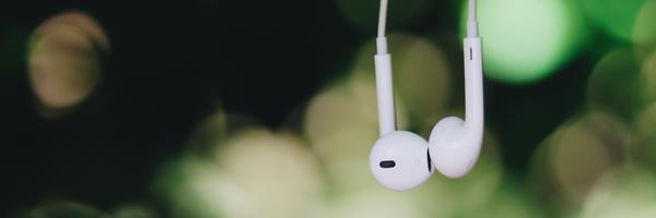 Earpods dangling green blurred backdrop feel good music Fatigue