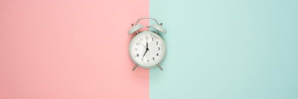 Vintage clock on pink and turquoise background